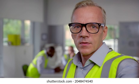 Mature Foreman Looking At Camera And Talking Having Video Call. Pov Shot Of Mid-adult Foreman Talking On Video Chat With Client In Office