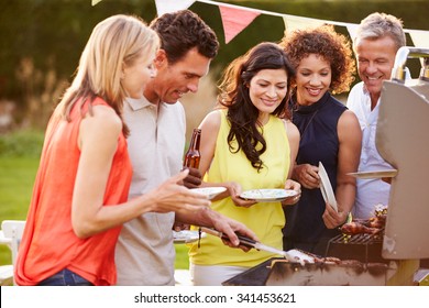 Mature Friends Enjoying Outdoor Summer Barbeque In Garden