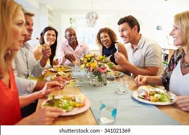 Mature Friends Sitting Around Table At Dinner Party