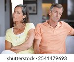 Mature, frustrated couple or argument with disagreement on sofa for fight, divorce or breakup at home. Upset, man and woman with ignore for conflict, dispute or toxic relationship on couch at house