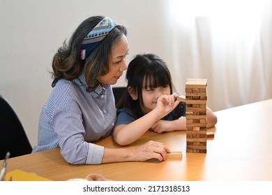 Mature Grandmother Having Fun Playing With Cute Little Preschooler Granddaughter In Living Room. Multi Generational, Family And Love Concept