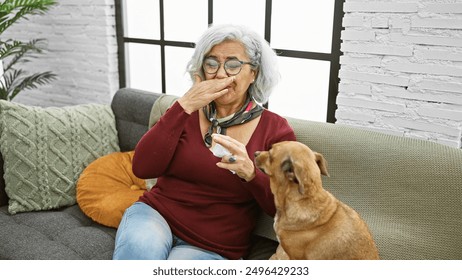 Mature grey-haired woman sneezing with tissue accomapnied by attentive dog in cozy living room - Powered by Shutterstock