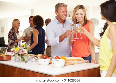 Mature Guests Being Welcomed At Dinner Party By Friends