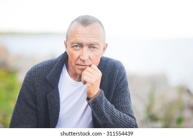 
Mature handsome gray-haired man close up looking at the camera and posing