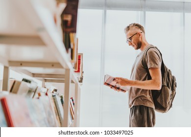 Mature Handsome Man Choosing Books At A Library Or A Book Store.