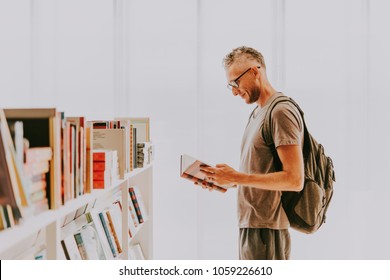 Mature Handsome Man Choosing Books At A Library Or A Book Store.