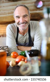 Mature Handsome Man Cooking In Home Kitchen