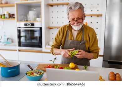 Mature Handsome Man Cooking In Home Kitchen