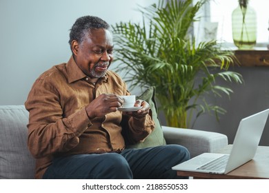 Mature Handsome Man Sitting On The Sofa Drinking Coffee. A Senior Black Man Enjoys A Cup Of Coffee At Home. Elderly Man At Home Drinking Coffee 