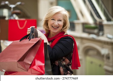 Mature Happy Blonde Woman With Shopping Bags