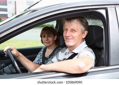 Mature Happy Caucasian Couple Sitting In Domestic Car And Smiling