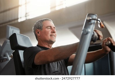 Mature, happy man and chest press with machine for workout, fitness or indoor exercise at gym. Active male person with earphones on equipment for strength, muscle gain or training at health club - Powered by Shutterstock