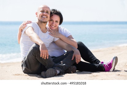 Mature Happy Spanish  Couple Smiling Holding Each Other On The Beach 