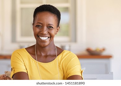 Mature Happy Woman Smiling And Looking At Camera. Portrait Of African American Woman In Casual Clothing And Curly Short Hair Relaxing At Home.  Portrait Of Successful Black Lady With Copy Space.