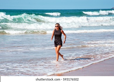 Mature Healthty Woman Running At The Beach