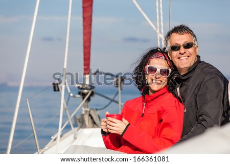 Mature heterosexual couple enjoying on the bow of a Sail boat