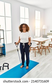 Mature Hispanic Woman Doing Exercise With Elastic Bands At The Living Room At Home