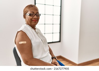 Mature Hispanic Woman Getting Vaccine Showing Arm With Band Aid With A Happy And Cool Smile On Face. Lucky Person. 