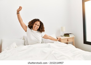 Mature Hispanic Woman Waking Up From Bed At The Bedroom