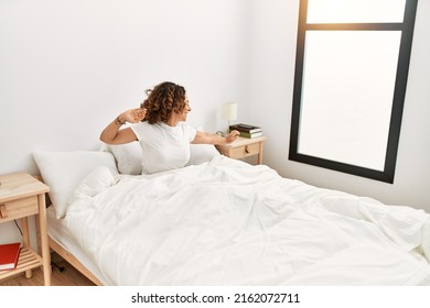 Mature Hispanic Woman Waking Up From Bed At The Bedroom