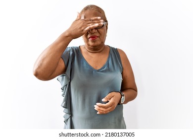 Mature Hispanic Woman Wearing Glasses Standing Over Isolated Background Covering Eyes With Hand, Looking Serious And Sad. Sightless, Hiding And Rejection Concept 