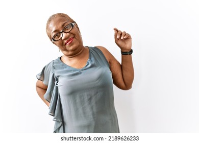 Mature Hispanic Woman Wearing Glasses Standing Over Isolated Background Stretching Back, Tired And Relaxed, Sleepy And Yawning For Early Morning 