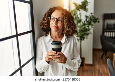 Mature Hispanic Woman Working Drinking A Coffee At The Office