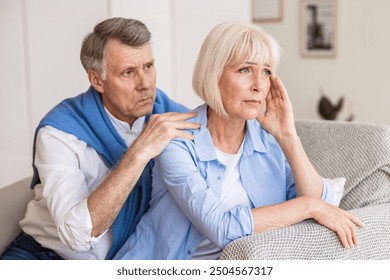 Mature husband and wife arguing, man trying to resolve family conflict at home - Powered by Shutterstock