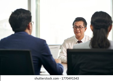 Mature Job Seeker Asian Business Man Being Interviewed By Young Human Resources Executives