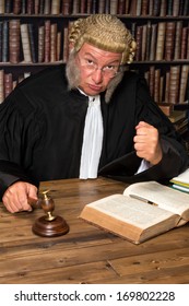 Mature judge with authentic court wig holding a gavel in court