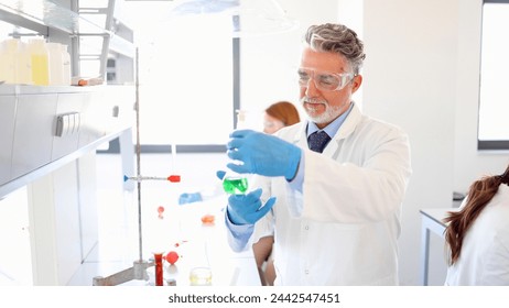 Mature lab specialist working on some chemical samples at his laboratory