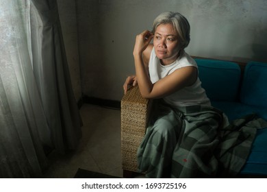 crisis de las mujeres maduras - retrato de estilo de vida interior de una mujer de mediana edad con el pelo gris triste y deprimido en el sofá sintiéndose frustrada y pensando sola sobre el envejecimiento solitario sufriendo depresión 