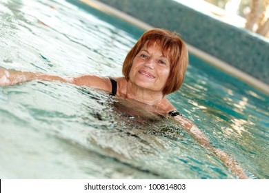 Mature Lady Swimming At Swimming Pool.