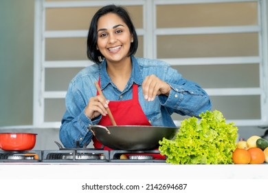 Mature Latin American Woman Preparing Vegetarian Food At Kitchen