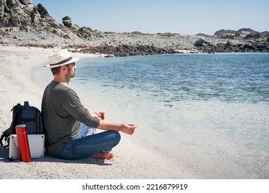 Mature Latin Man Sitting On The Shore Of The Beach Meditating Relaxed