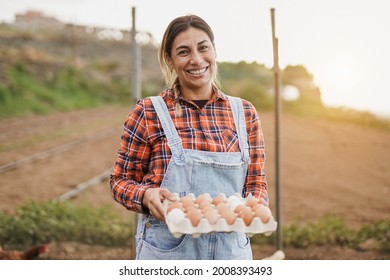 Mature Latin Woman Holding Fresh Eggs - Elderly Farmer Person Smiling In Camera