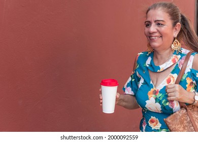 Mature Latina Woman With Coffee Walking Outdoors In Town Or City