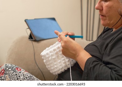 Mature Latina Woman Knits At Home, Learning Handicrafts Online.