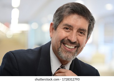 Mature latino businessman smiling inside an office building