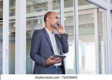 Mature leader talking on phone and looking away. Senior business man in formal have a serious conversation at cellphone. Businessman discussing over phone during working call. - Powered by Shutterstock