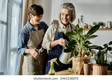 Mature lesbian couple in aprons nurturing a plant together. - Powered by Shutterstock