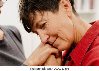 Mature Lesbian Couple Holding Hands And Smiling At Home