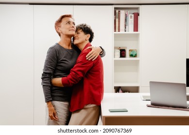 Mature Lesbian Couple Hugging And Smiling At Home