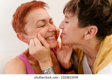 Mature Lesbian Couple Laughing While Making Fun Together At Home