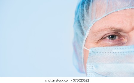 Mature Mail Surgeon In Hospital Closeup Portrait On Blue Background With Copyspace.