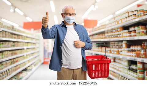 Mature Male Customer With A Face Mask And A Shopping Basket In A Supermarket Showing A Thumb Up Sign