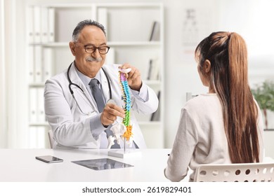 Mature male doctor explaining a cervical spine model to a female patient at the office  - Powered by Shutterstock - Get 15% off with code: PIKWIZARD15