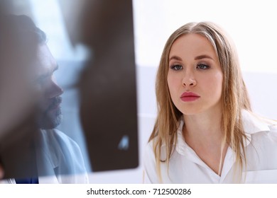 Mature male doctor hold in arm and look at xray photography discussing it with female patient portrait. Bone disease exam, medic assistance, cancer test, healthy lifestyle, hospital practice concept