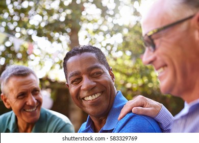 Mature Male Friends Socializing In Backyard Together