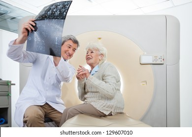 Mature Male Radiologist With An Elderly Female Patient Looking At CT Scan Results